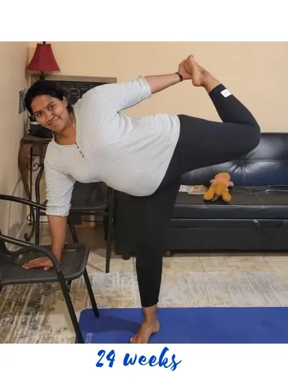 Using a chair for support in Dancer's Pose at 24 weeks is a smart way to practice balancing poses safely.
