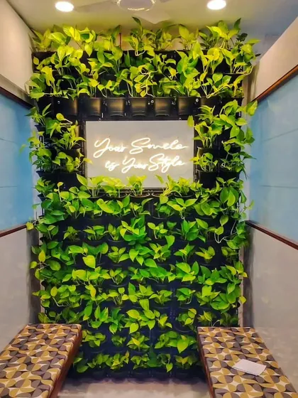 Even a small space can make a big green statement. In this dentist's waiting room, I installed a vertical garden around a neon sign, creating a calming and stylish focal point that helps ease patient anxiety.