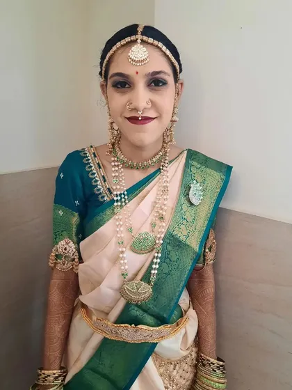 Bride Shalini looking serene and beautiful for her main wedding ceremony. This shot highlights the complete look, from the perfectly draped saree and layered necklaces to the flawless makeup base.