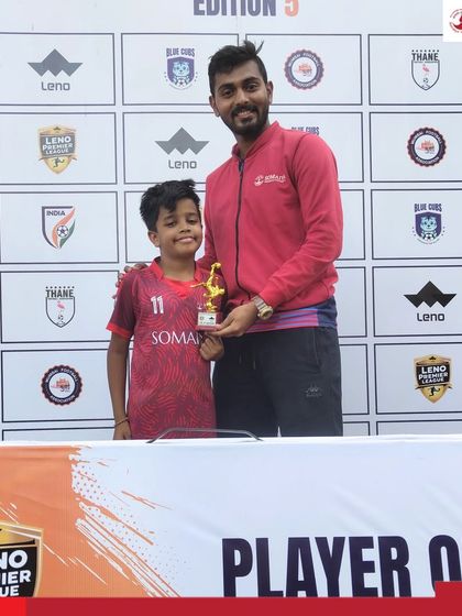 A coach presents the Man of the Match trophy to Madhav Verma of the U-8 team for his four-goal performance.