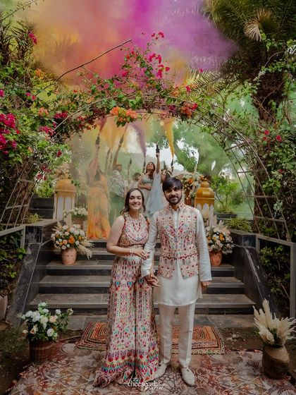 A full-length portrait of the couple at their colorful carnival-themed event.