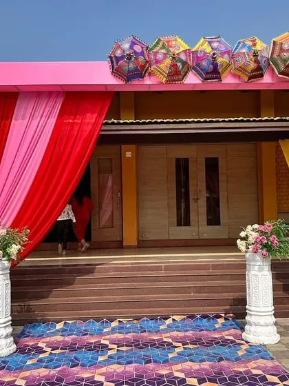 A grand entrance gate we designed for a wedding event, decorated with pink drapes and topped with colorful, traditional umbrellas. This sets a festive tone right from the moment your guests arrive.