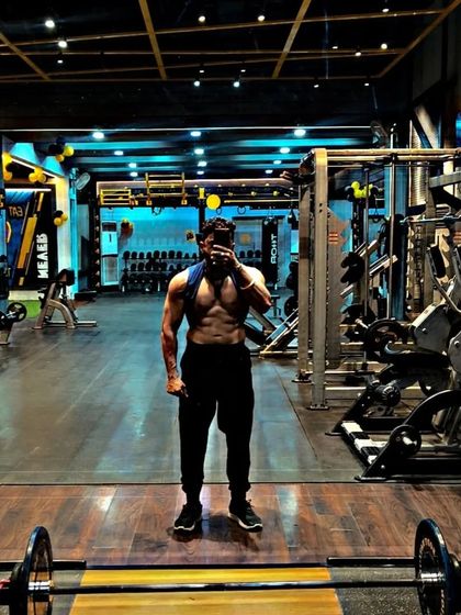 Stronger. A simple statement backed up by a physique that shows power and definition in a full gym setting.