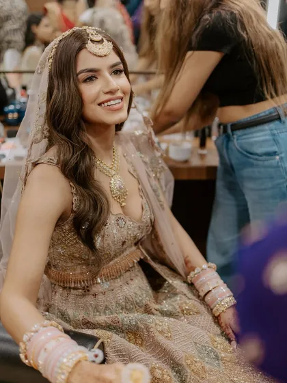 A happy bride in the makeup chair. Her smile shows her confidence and joy in the soft, natural look we created for her.