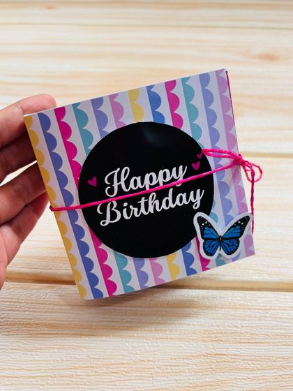 The keepsake mini album tied shut with a pink string, showing how small and portable it is.