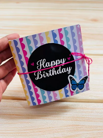 The keepsake mini album tied shut with a pink string, showing how small and portable it is.