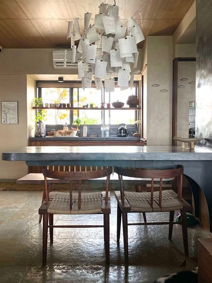 The cantilevered dining table, seen here from a different angle, is a central feature of the home. It anchors the open-plan living space and serves as a gathering point for meals and conversations.