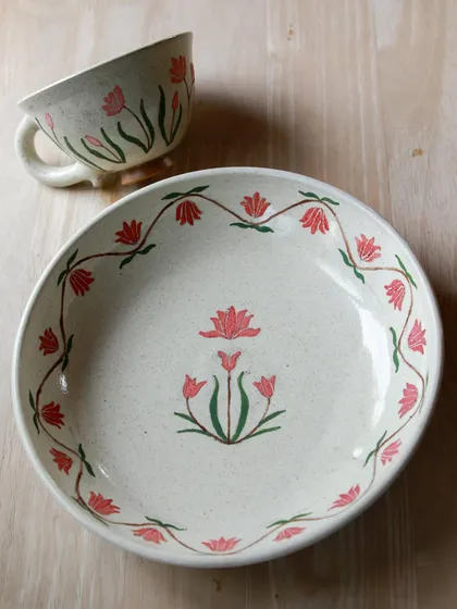 This plate and cup set features a beautiful, intricate floral design that wraps around the rim. It's a piece that tells a story of patience and artistry.
