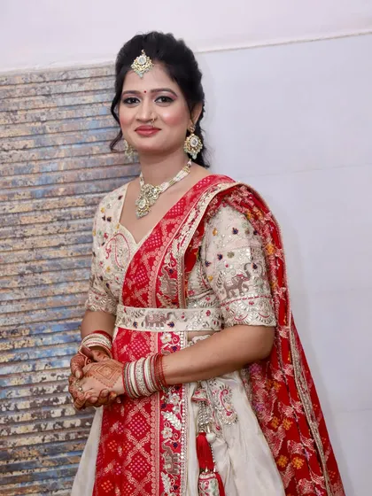 An elegant party look in a white and red lehenga. The makeup is kept classic and radiant, with a traditional touch.