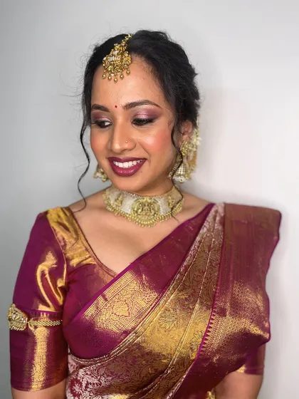 A close-up view of the soft, romantic makeup. The eyeshadow has a hint of pink shimmer, which beautifully complements the deep magenta of her saree.
