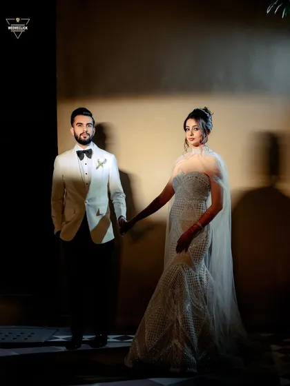 A moody and artistic shot of the couple holding hands, with dramatic shadows creating a powerful visual.