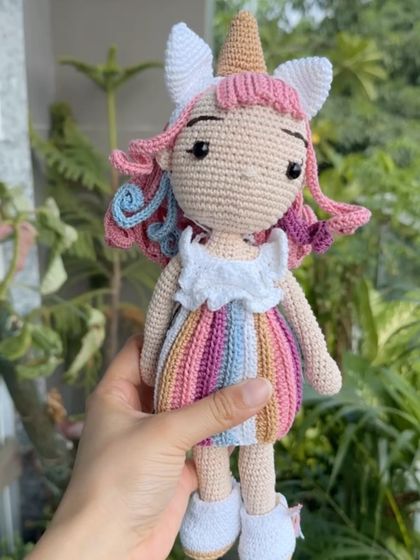 A close-up of the Bella unicorn doll, highlighting her colorful dress and unique, hand-stitched features.