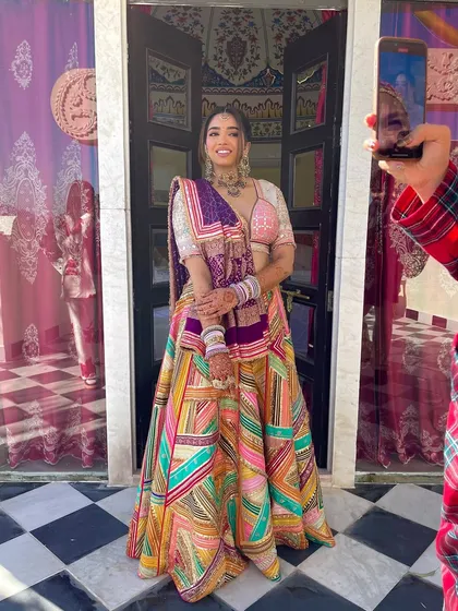 A behind the scenes shot of the bride posing for photos. Her unique braided hairstyle is a conversation starter.