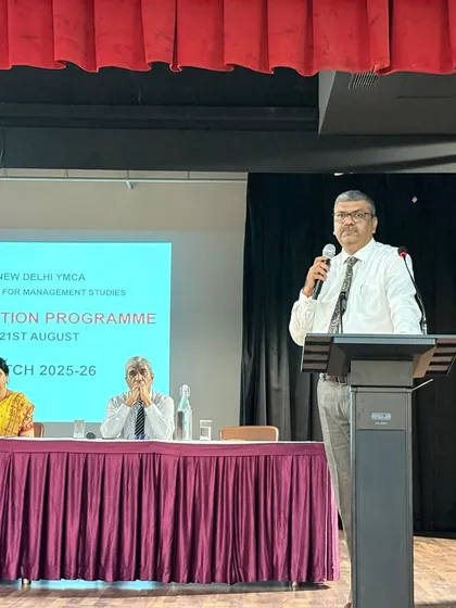 A faculty member speaking at the podium during the Orientation Programme, welcoming students and outlining the path ahead at the Institute for Management Studies.