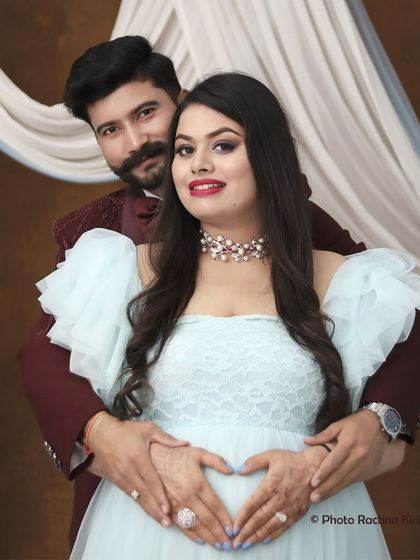 A beautiful close-up of the couple, with his hands forming a heart on her belly. This classic pose is a simple yet powerful symbol of their love and the new life they have created together.