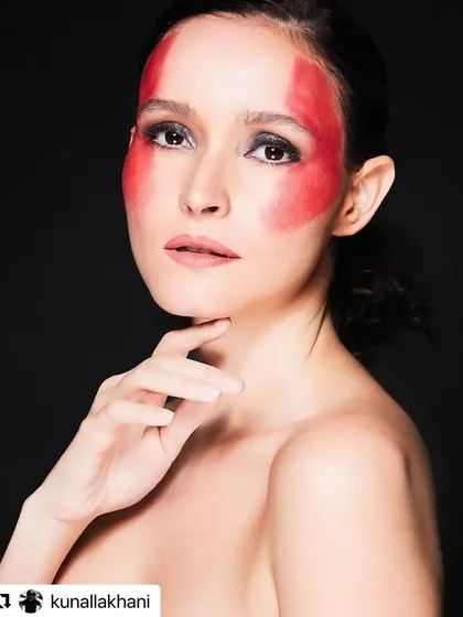 Pushing creative boundaries is a passion of mine. For this conceptual shoot, I used bold red face paint to create a graphic, monochromatic look, demonstrating my skills in artistic and avant-garde makeup for high-fashion editorials.