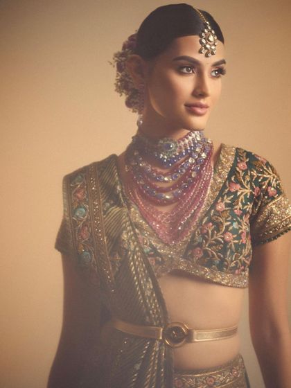 A modern take on a bridal look with a unique layered necklace. The makeup is kept elegant and understated, with a focus on flawless skin and softly defined features to complement the statement jewellery.