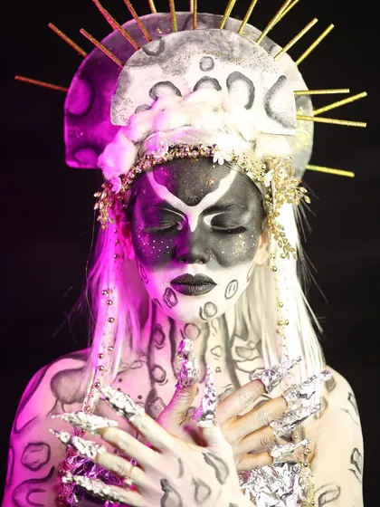 A serene pose that highlights the beautiful contrast between the dark makeup and the white hair and accessories.