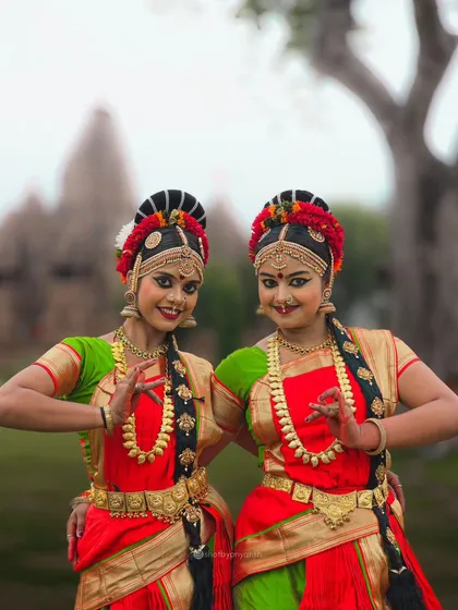 Two Kuchipudi dancers pose in a traditional stance with the Khajuraho temples in the background. A shot that blends culture, art, and technology.