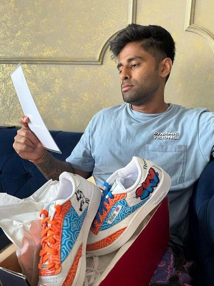 Cricketer Suryakumar Yadav looking over the design sheet for his custom Reebok sneakers.