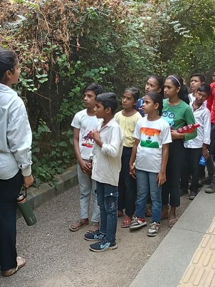 A team member guides a group of students from Free Paathshala along the restored corridor, pointing out different native plants and insects.
