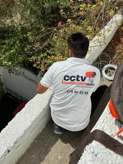 My team member, wearing our cctvinstallationwalla branded shirt, works on an outdoor wiring job. We are proud of the professional identity we bring to every site.