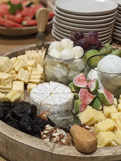 A bountiful cheese platter from an event with Cetaphil and One Impression. It features a wheel of brie, fresh figs, prunes, nuts, and mozzarella balls, offering a rich variety of flavours and textures.