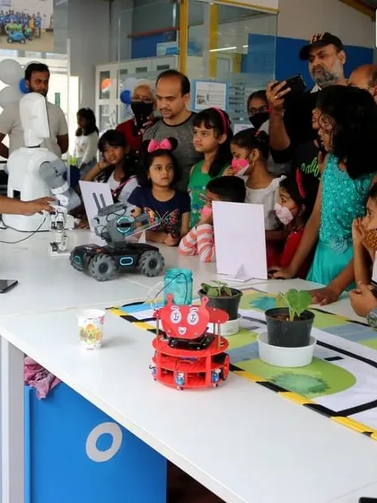 An instructor demonstrates a robot's capabilities to an excited group of kids and parents at a RoboExpo. These events are a great way for the community to experience the magic of robotics firsthand.