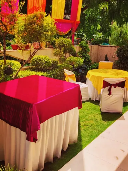 Table and chair setup in a garden space for a Mehandi function. I use different colored tablecloths to match the vibrant theme of the event.
