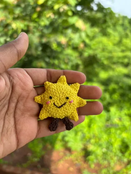 A solo shot of the happy sun keychain. It's a little pocketful of sunshine to brighten your day.