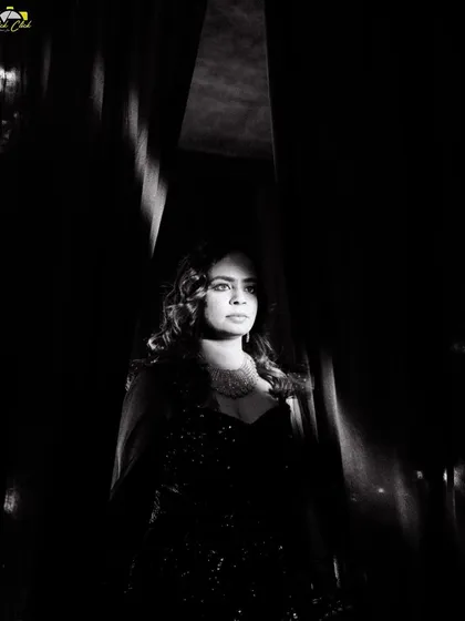 A stunning black and white portrait of Komal, using dramatic lighting to create a moment of quiet elegance before the party began.