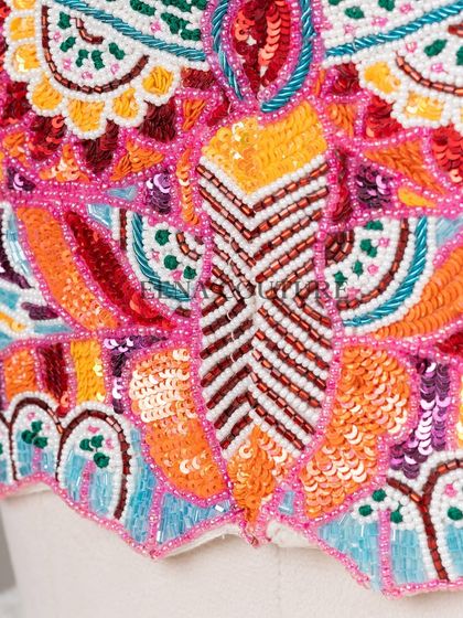 I designed this unique 'Butterfly Garden' blouse for the bride who loves color and artistry. The entire piece is covered in a vibrant mosaic of multi-colored beads and sequins, forming a stunning butterfly motif across the back.