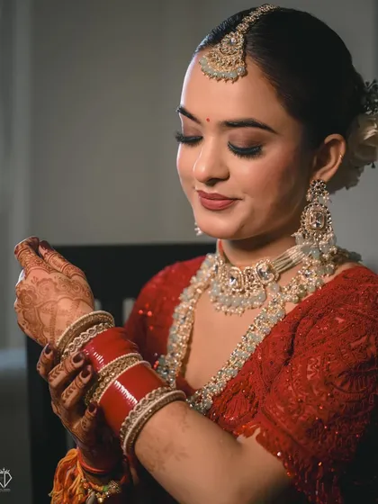 A serene portrait of the bride as she looks down at her hands. The focus on her intricate jewelry and calm expression tells a story of quiet confidence.