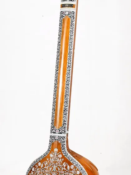 An angled view of the floral tanpura's neck and body, highlighting the seamless craftsmanship.
