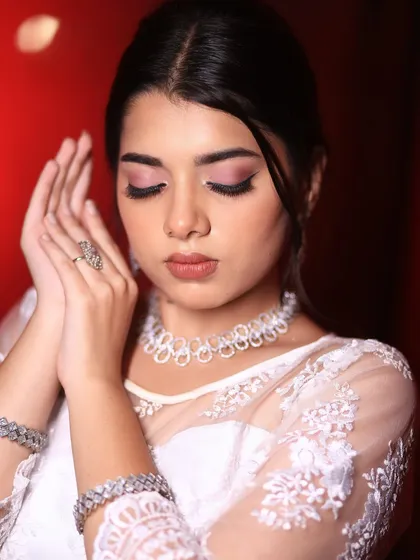 A serene and beautiful shot focusing on the soft pink eyeshadow. This subtle touch of color adds warmth to the face without distracting from the overall elegance of the white dress.