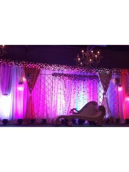 A simple yet beautiful stage for a lockdown event. The use of purple and white lighting on a draped backdrop with a lattice pattern shows how we can create a wonderful ambiance even in a compact space.