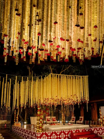 A close-up of a stunning ceiling treatment with hanging tuberose garlands and red roses above the mandap. This showcases my focus on creating a complete 360-degree experience.