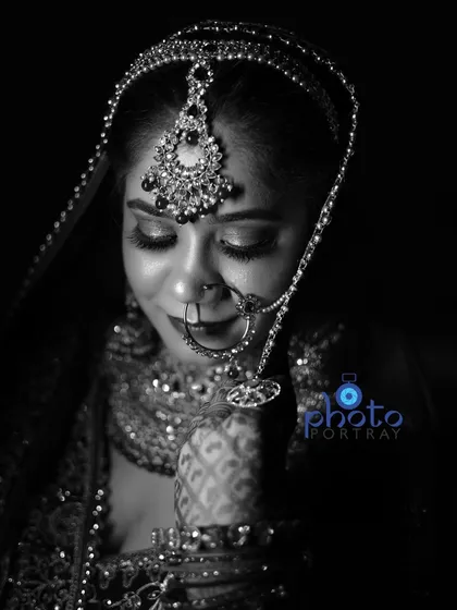 A timeless black and white bridal portrait. This artistic shot focuses on the bride's expression and the beautiful details of her maang tikka and nath.