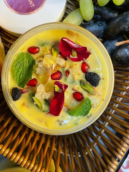 An overhead shot of our fruit custard, garnished with fresh fruits, nuts, and edible flowers. It's a beautiful and delicious dessert for Navratri.