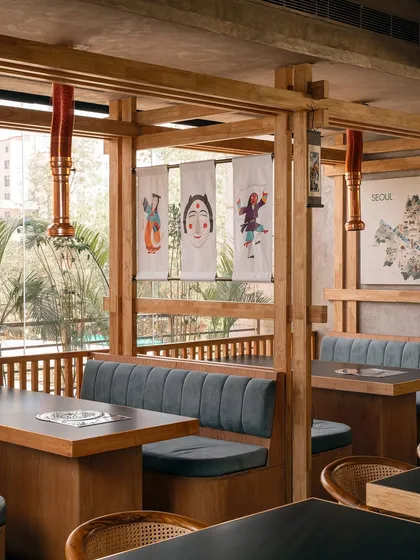 The booth seating at Seoul provides a comfortable and intimate setting for diners. The design uses a simple material palette of wood and fabric, accented by traditional Korean artwork to create a welcoming and authentic atmosphere.