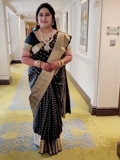 A candid moment showing the beautiful fall of the pre-pleated black Kanjeevaram. The saree looks just as perfect in motion as it does in portraits.