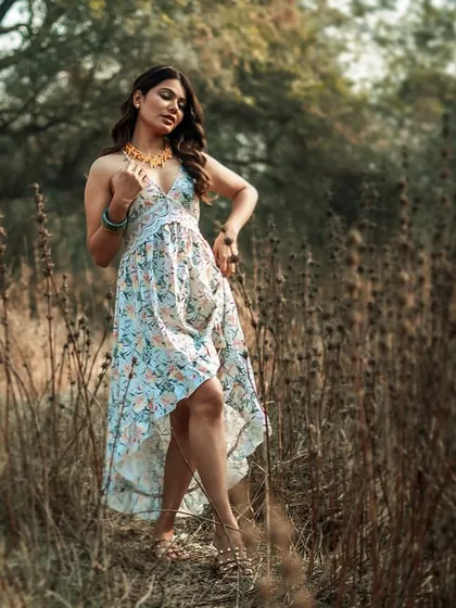 Posing is crucial for showcasing both the model and the clothing. This pose, with its elegant lines and composition, highlights the flow and cut of the high-low dress against the rustic backdrop.