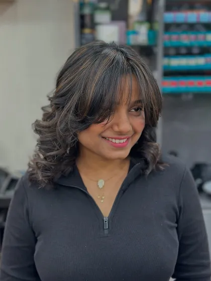 A lovely side profile of the copper highlights and curly bob. It's a playful and stylish look that's full of personality.