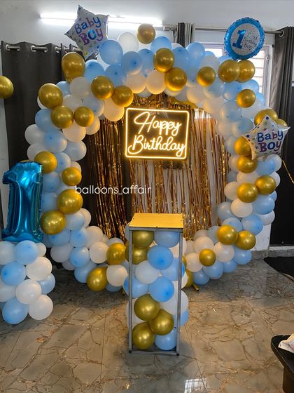 A clear view of the baby boy's first birthday setup, including a plinth for the cake.