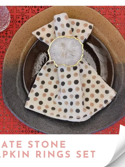 A set of agate stone napkin rings, shown styling a polka-dotted napkin. These are perfect for elevating your tablescape for a dinner party or festive meal.