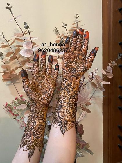 This bridal design combines bold leaf motifs with fine, delicate line work, creating a beautiful contrast that extends up the arm.