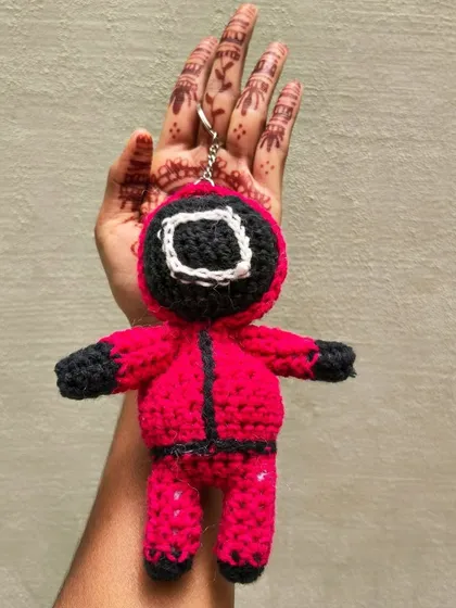 A clear shot of the Squid Game guard keychain, showing the stitch details.