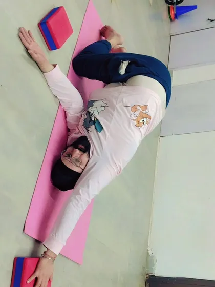 A student performs a deep spinal twist, a great pose for improving spinal mobility and aiding digestion. We welcome everyone in our classes, creating a supportive space for all.