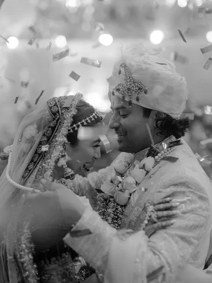 A black and white shot of Sharun and Sambhav during their Jaimala, with confetti raining down. This captures the peak celebratory moment in a timeless and emotional way.