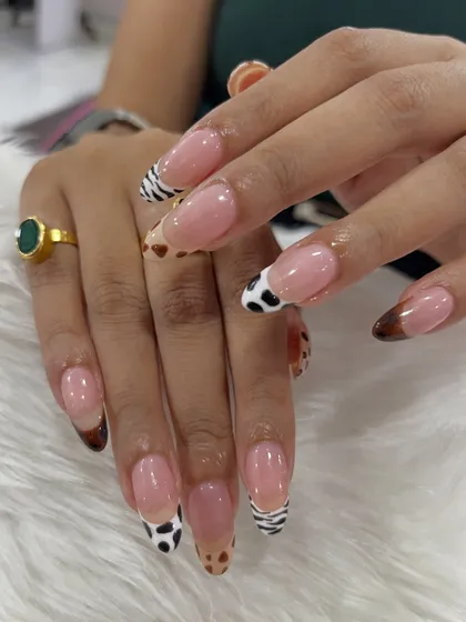 For the client who wants something truly unique, I designed these French tip nail extensions with a wild twist. Each tip features a different hand-painted animal print, including zebra, cow, and leopard, for a playful yet chic look.